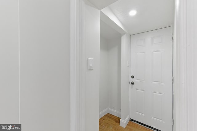 doorway to outside featuring baseboards and light wood finished floors