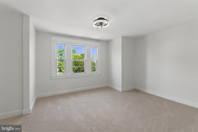 empty room with light colored carpet and baseboards