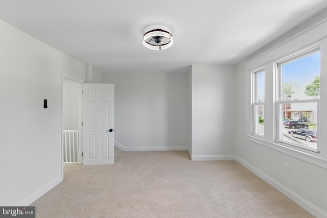 carpeted empty room featuring baseboards