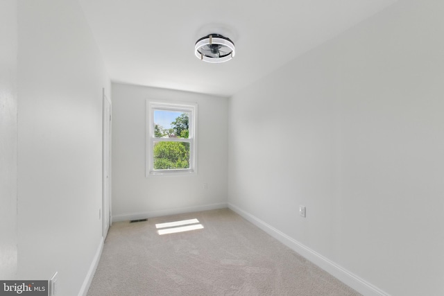 carpeted spare room with baseboards