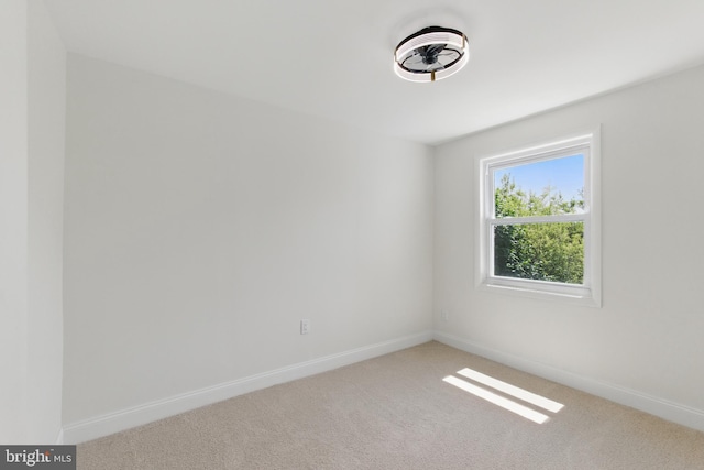 unfurnished room featuring carpet and baseboards