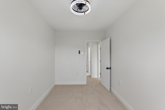 empty room with light colored carpet and baseboards