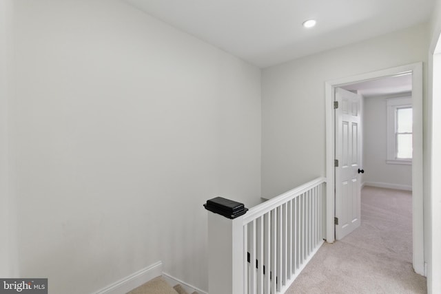 corridor featuring an upstairs landing, light carpet, baseboards, and recessed lighting