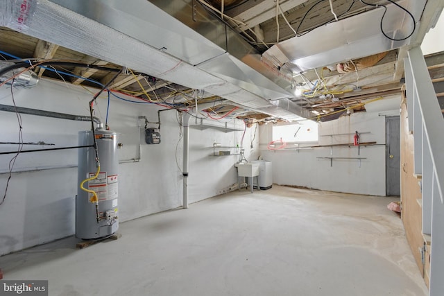 basement featuring water heater and a sink