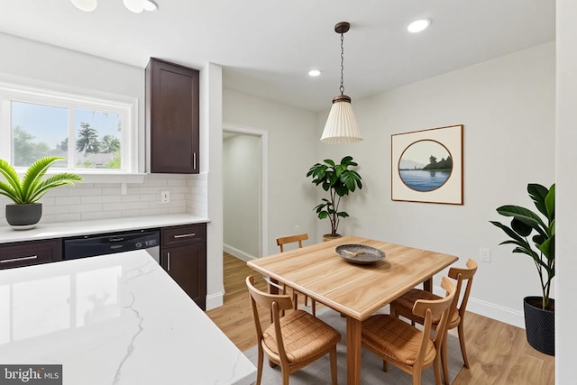 dining space with baseboards, light wood finished floors, and recessed lighting