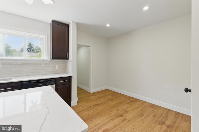 kitchen featuring dishwashing machine, light wood finished floors, light stone counters, tasteful backsplash, and dark brown cabinets