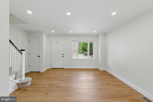 entrance foyer featuring light wood finished floors, recessed lighting, stairs, and baseboards