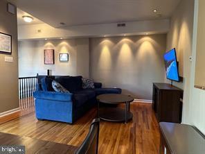 home theater room featuring wood finished floors and baseboards
