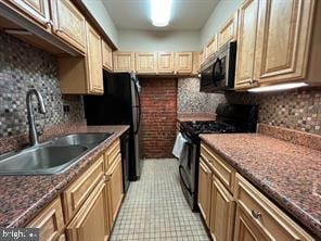 kitchen with gas range oven, stainless steel microwave, a sink, and backsplash