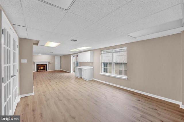 28 W Houndpack Way, Glen Mills, PA 19342 - unfurnished living room with a drop ceiling, baseboards, and light wood-style flooring