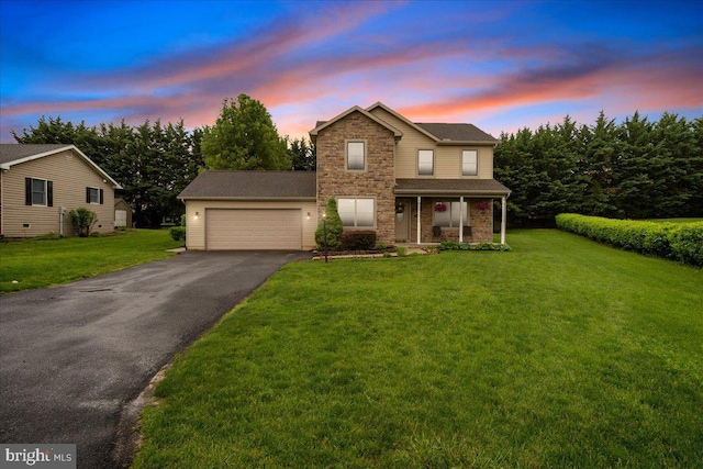 192 Antietam Dr, Waynesboro, PA 17268 - traditional home with asphalt driveway, an attached garage, a porch, a yard, and stone siding