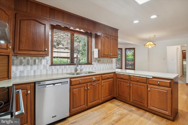 kitchen with dishwasher, a sink, a peninsula, light countertops, and recessed lighting