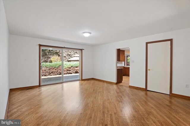empty room with light wood-style flooring and baseboards