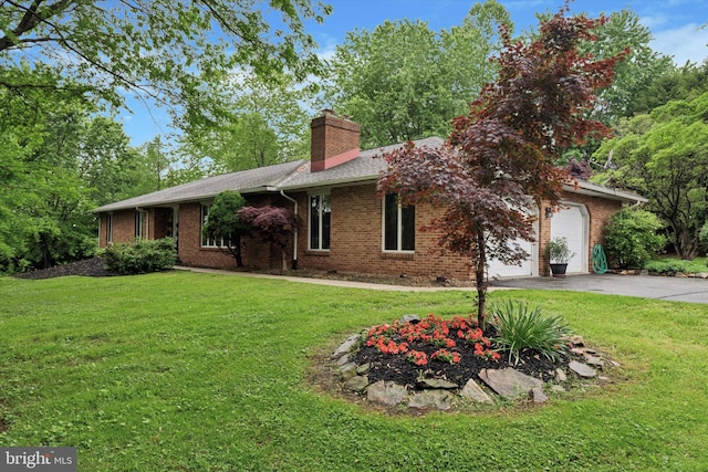 ranch-style house featuring asphalt driveway, a garage, a chimney, and a front yard