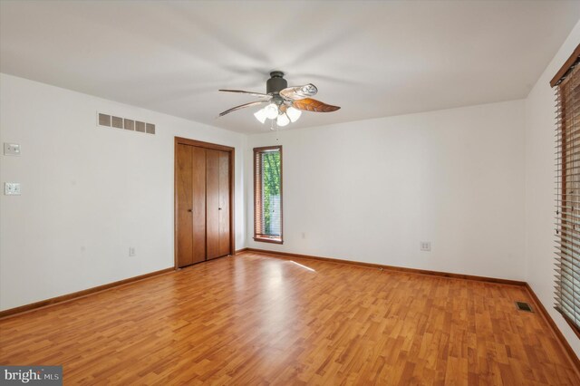 unfurnished bedroom featuring light wood-type flooring, baseboards, and a ceiling fan