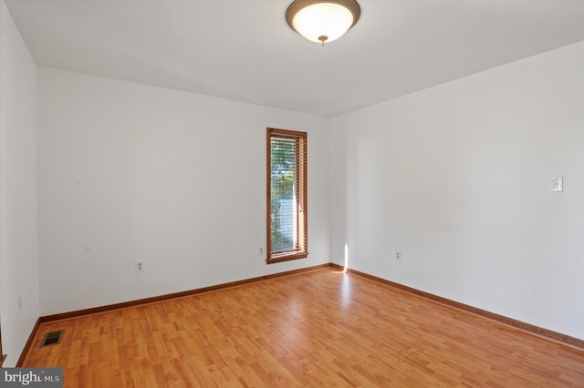 spare room featuring light wood-style floors and baseboards