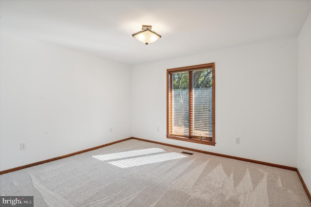 carpeted empty room featuring baseboards