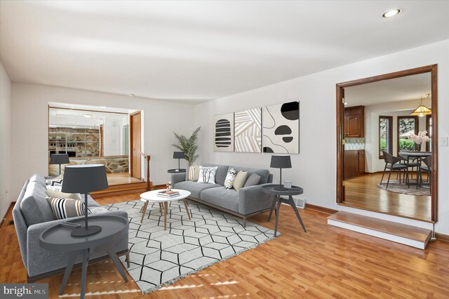living area featuring light wood-type flooring, recessed lighting, and baseboards