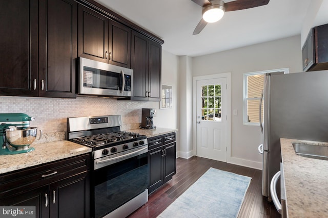 kitchen featuring appliances with stainless steel finishes, tasteful backsplash, a ceiling fan, baseboards, and dark wood finished floors