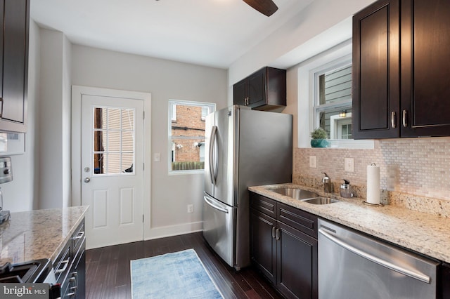 kitchen with appliances with stainless steel finishes, tasteful backsplash, light stone countertops, dark wood-style floors, and dark brown cabinetry