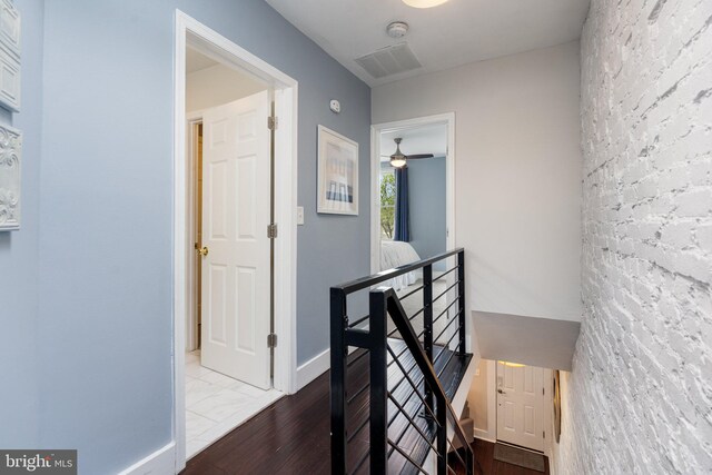 stairway with wood finished floors, baseboards, and a ceiling fan