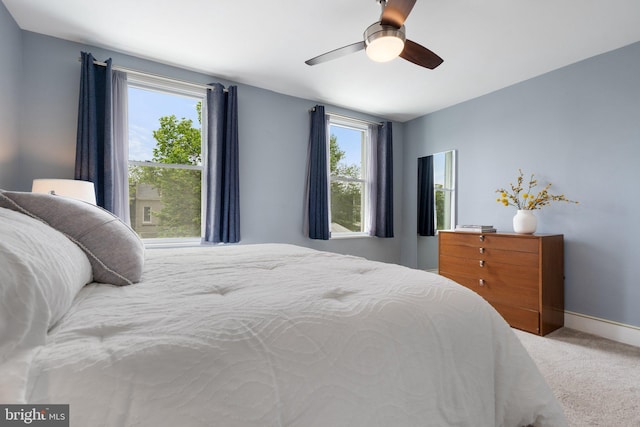 bedroom featuring light carpet, ceiling fan, and baseboards