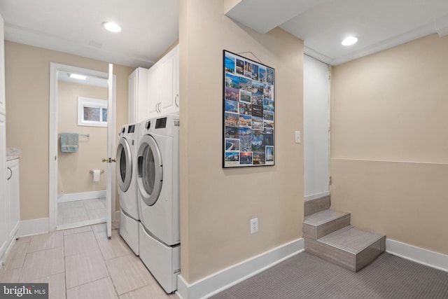 clothes washing area featuring washing machine and dryer, cabinet space, baseboards, and recessed lighting