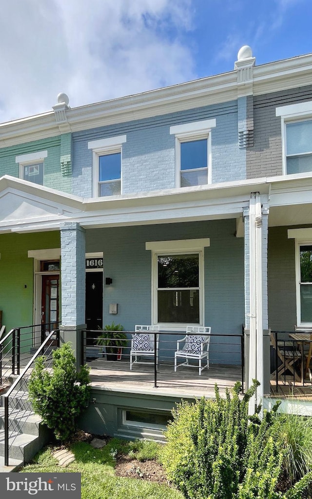 view of front of house featuring brick siding and covered porch