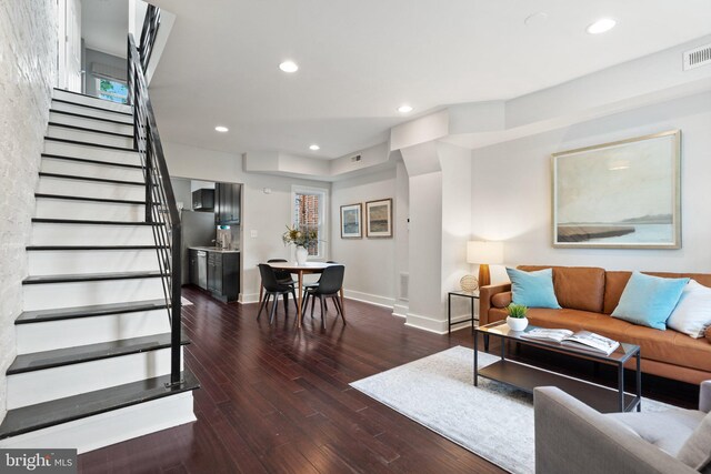 living room with wood finished floors, stairway, baseboards, and recessed lighting