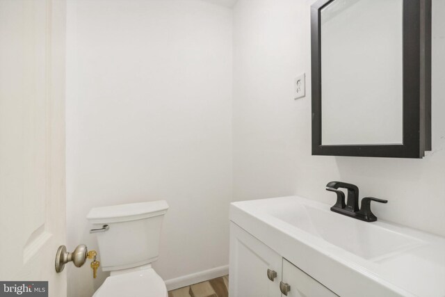 702 Main St, Darby, PA 19023 - half bathroom featuring toilet, vanity, wood finished floors, and baseboards