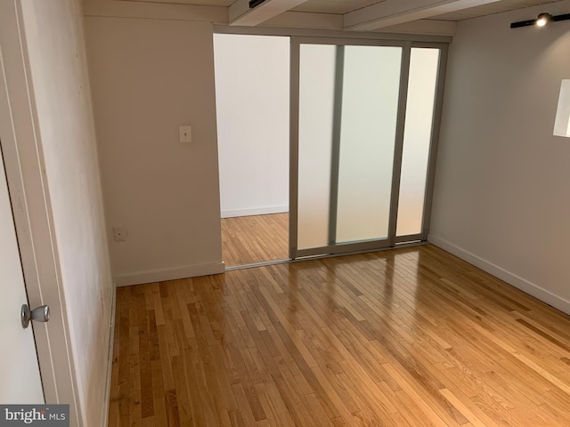 unfurnished bedroom featuring light wood-type flooring and baseboards