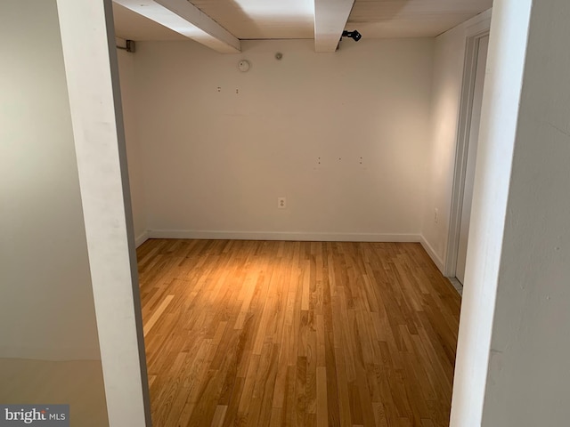 unfurnished room with light wood-type flooring and baseboards