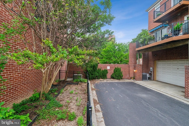 800 S Charles St, Baltimore, MD 21230 - view of yard featuring a balcony, driveway, an attached garage, fence, and central AC unit