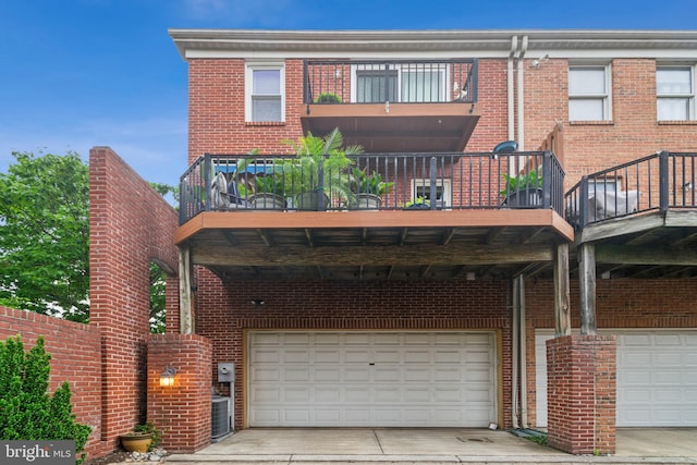 800 S Charles St, Baltimore, MD 21230 - rear view of house with brick siding, a garage, concrete driveway, and a balcony