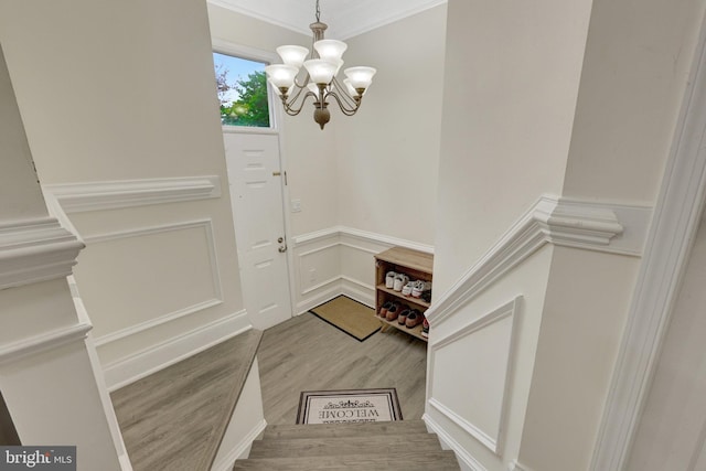21850 Goldstone Ter, Sterling, VA 20164 - staircase featuring wood finished floors, a chandelier, crown molding, a decorative wall, and wainscoting
