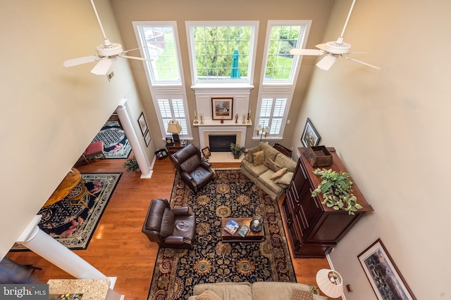 267 Goldenrod Dr, Upper Gwynedd, PA 19446 - living room featuring a ceiling fan, a towering ceiling, wood finished floors, and a fireplace with flush hearth