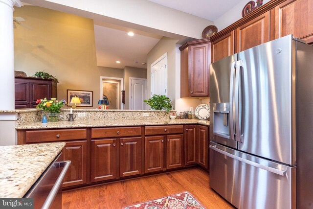267 Goldenrod Dr, Upper Gwynedd, PA 19446 - kitchen with stainless steel fridge with ice dispenser, light stone counters, light wood finished floors, recessed lighting, and brown cabinets