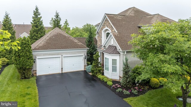 267 Goldenrod Dr, Upper Gwynedd, PA 19446 - view of front of house featuring a garage, a standing seam roof, stone siding, a front lawn, and a shingled roof