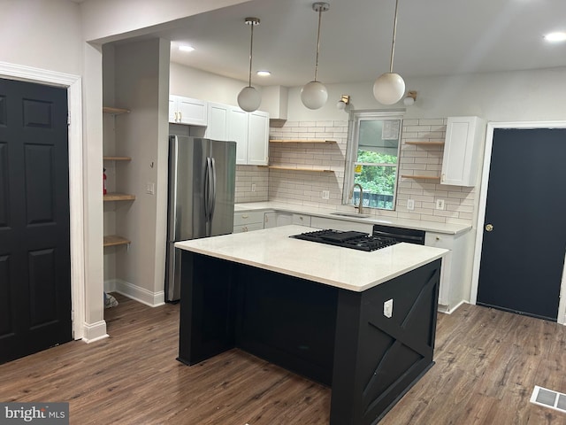kitchen featuring open shelves, freestanding refrigerator, black gas cooktop, a sink, and light countertops