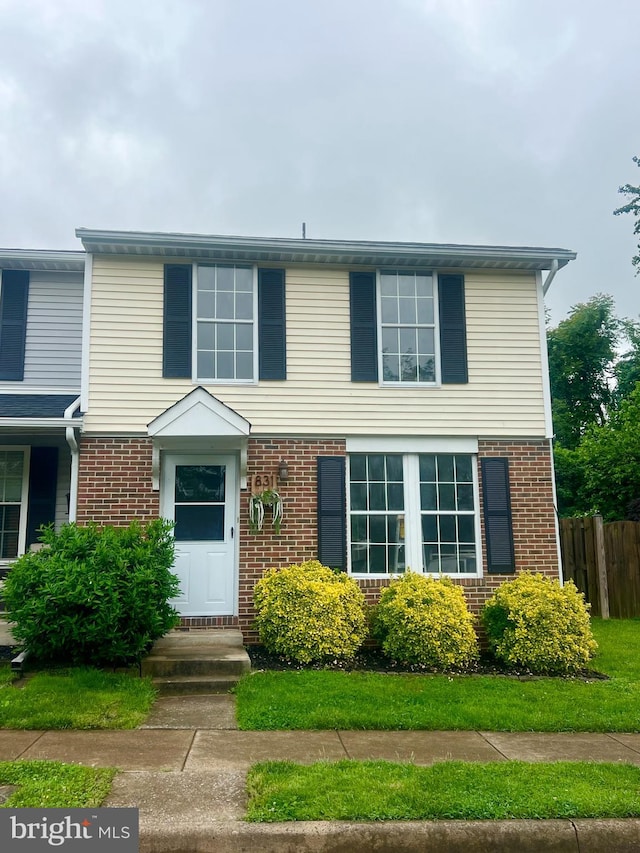 view of front of property featuring brick siding and fence