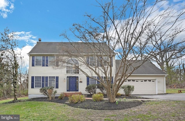 colonial house with asphalt driveway, a garage, a front lawn, and a shingled roof
