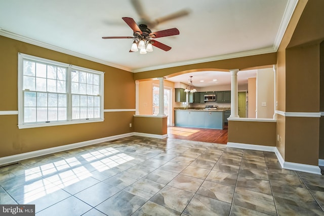 unfurnished living room featuring ornate columns, a ceiling fan, plenty of natural light, crown molding, and tile patterned floors