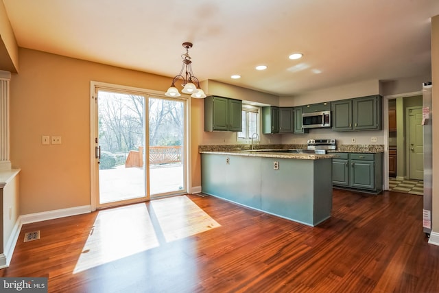 kitchen featuring stainless steel appliances, green cabinets, a peninsula, dark wood-type flooring, and recessed lighting