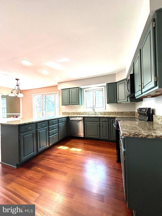 kitchen featuring appliances with stainless steel finishes, plenty of natural light, dark wood-style flooring, recessed lighting, and light stone countertops