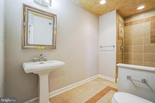 full bath with tile patterned flooring, tiled shower, toilet, recessed lighting, and baseboards