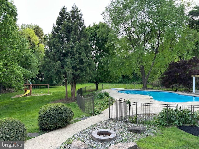 view of swimming pool featuring a patio area and view of wooded area