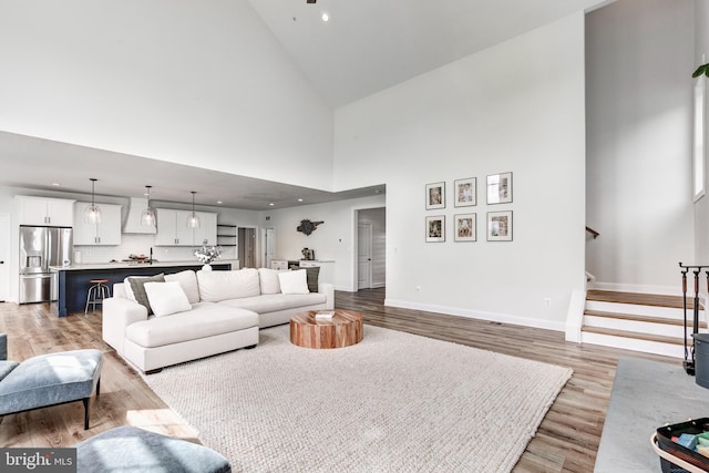 3471 Bullfrog Rd, Taneytown, MD 21787 - living area with light wood-style floors, stairs, high vaulted ceiling, baseboards, and recessed lighting