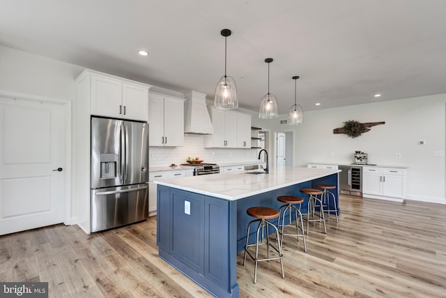 3471 Bullfrog Rd, Taneytown, MD 21787 - kitchen with stainless steel appliances, custom exhaust hood, light wood-style floors, a breakfast bar, and white cabinets