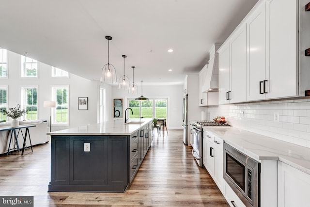 3471 Bullfrog Rd, Taneytown, MD 21787 - kitchen with appliances with stainless steel finishes, a sink, white cabinets, a large island, and light wood-type flooring