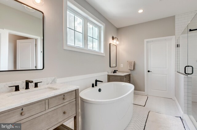 3471 Bullfrog Rd, Taneytown, MD 21787 - bathroom featuring a stall shower, a freestanding tub, two vanities, a wainscoted wall, and tile patterned flooring